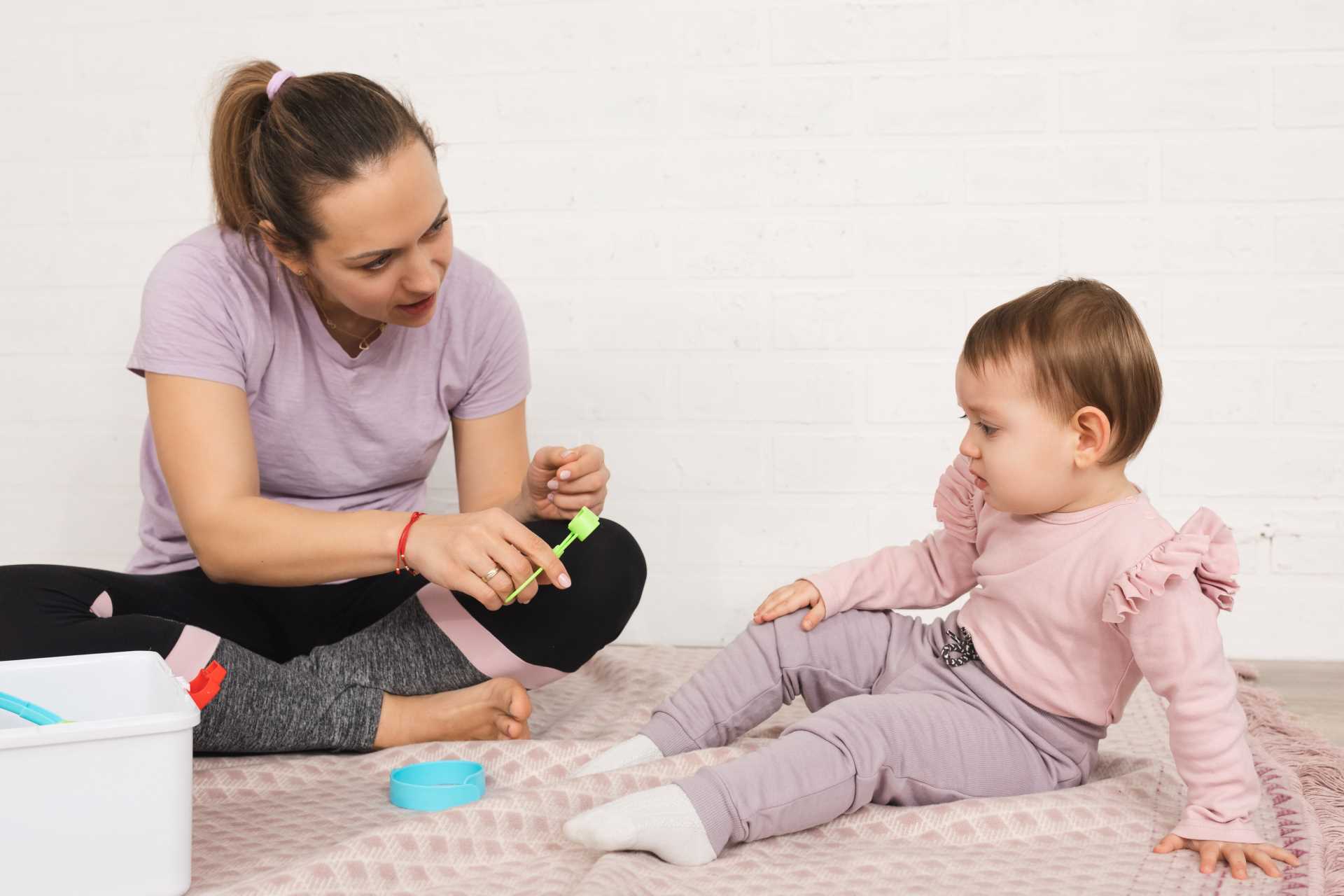 mother plays with her child at the doctor, preparing the child for the doctor's visit.